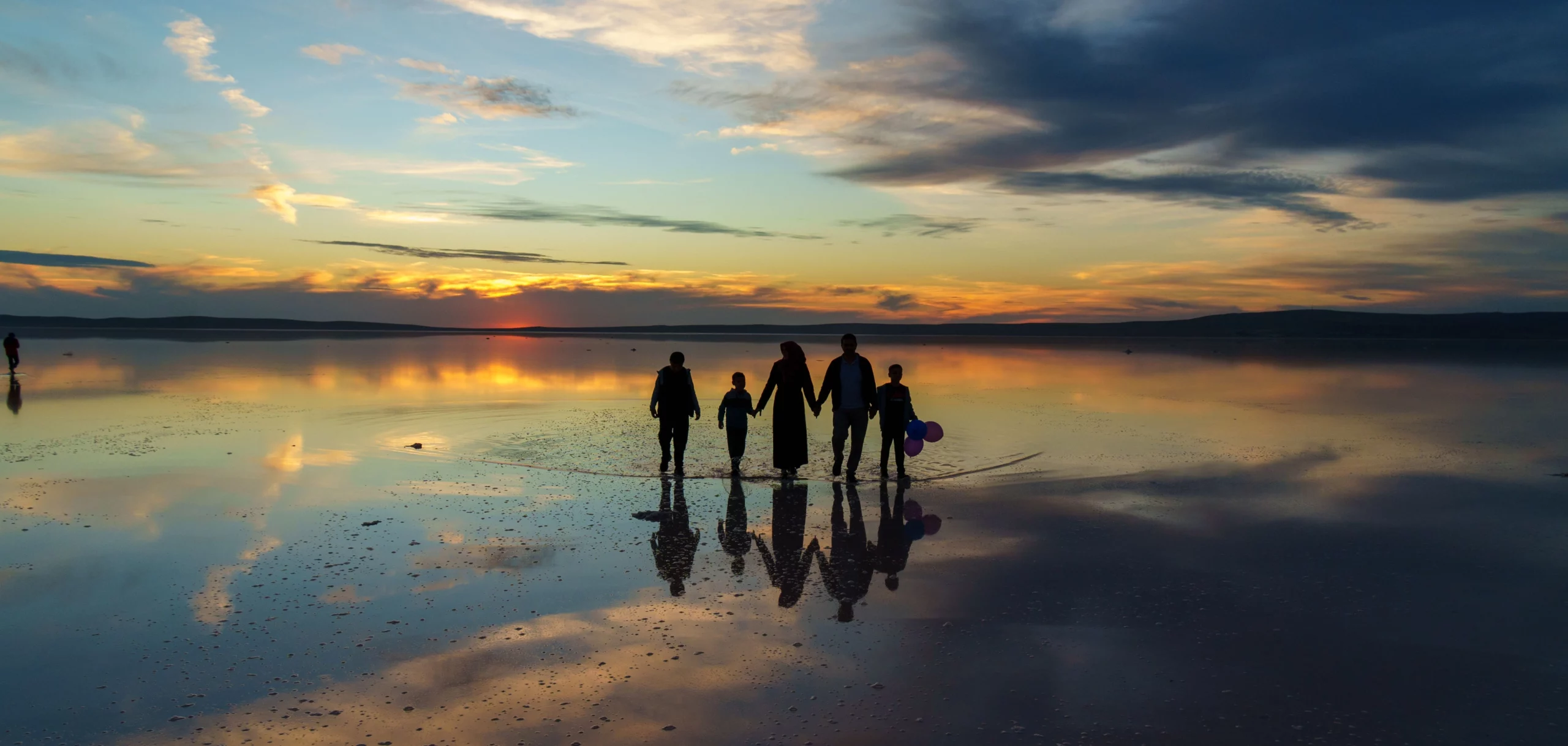 Famille marchant sur la plage au coucher du soleil